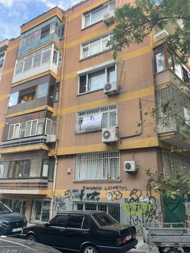 Binanın balkonlu cephesi ve pencere üzerindeki NOVACENT pankartı