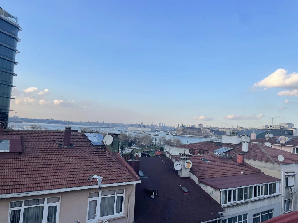 Çatıların ardından görünen kıyı ve deniz manzarası