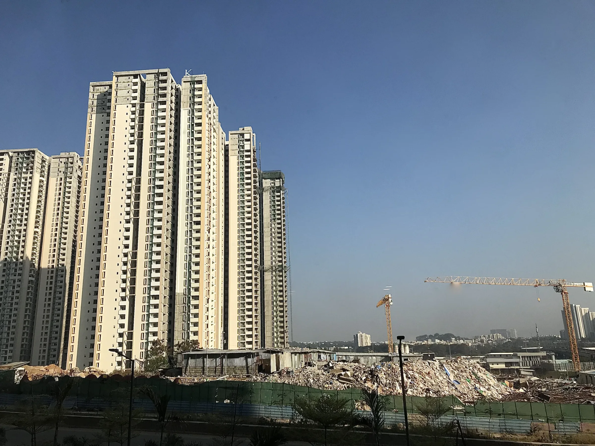Hyderabad'da gün ışığında yapımı süren yüksek katlı binalar ve şantiyedeki kule vinçler.